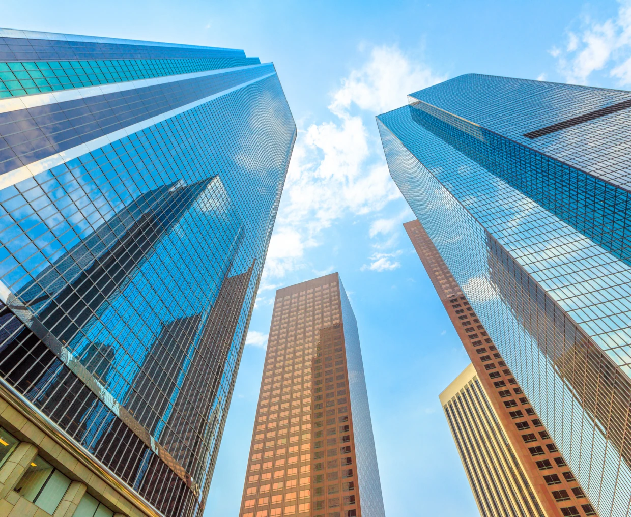 Skyscrapers against blue sky with clouds.